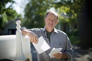 man leaning on mailbox